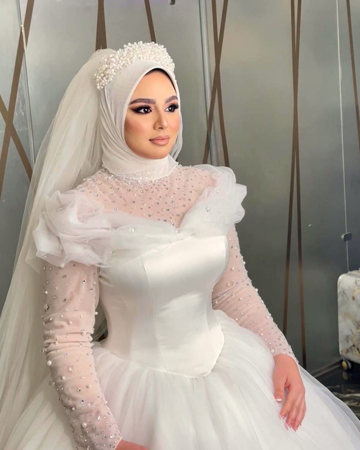 فستان عروسه طويل للمحجبات ابيض من الساتان و التل مرصع بالأحجار البراقة و بأكمام طويلة - صور فساتين افراح محجبات