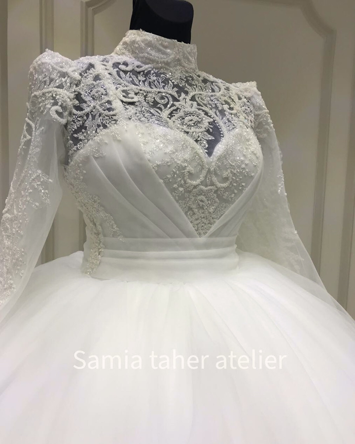 فستان زفاف ابيض طويل منفوش من التول بصدر مطرز بالترتر والخرز اللامع وباكمام طويله - فساتين افراح لغير المحجبات