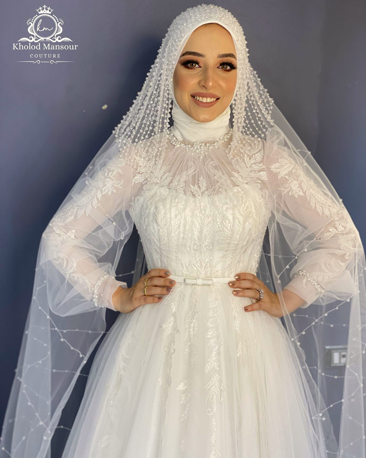 فستان عروسه أبيض طويل بالتول مطرز بالخرز اللامع بطرحه من التل بحزام للخصر للمحجبات وباكمام طويله - فساتين الزفاف للمحجبات